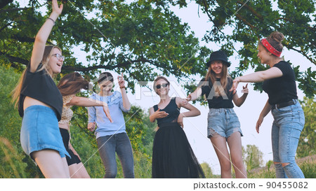 Girls are dancing outside the city on a picnic. Girls are dancing outside the city on a picnic. 90455082