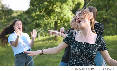 Joyful girls are dancing on a picnic near the forest. Joyful girls are dancing on a picnic near the forest. 90455088