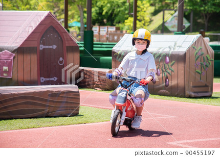 Elementary school girl riding a kids bike Elementary school girl riding a kids bike 90455197