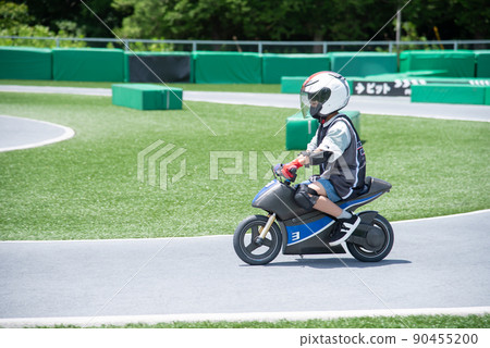 Elementary school boy riding an electric motorcycle 90455200