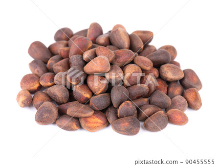 Pine nuts isolated on white background. Heap of raw pine nuts in shells Pine nuts isolated on white background. Heap of raw pine nuts in shells 90455555