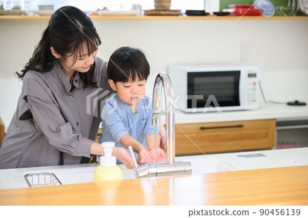 Toddler washing hands with mom 90456139