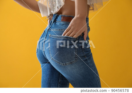 Woman wearing jeans on yellow background, closeup 90456578