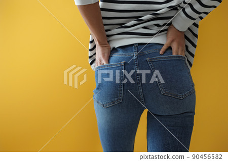 Woman wearing jeans on yellow background, closeup 90456582