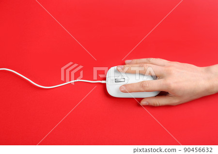 Woman using modern wired optical mouse on red background, top view 90456632