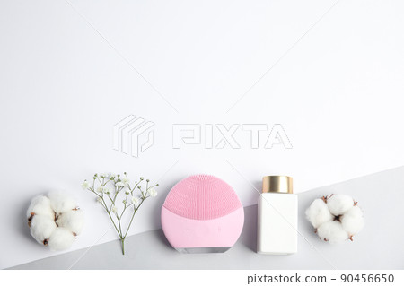 Flat lay composition with face cleansing brush on color background, space for text. Cosmetic accessory 90456650