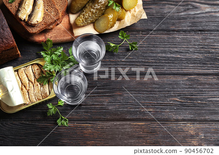 Flat lay composition with cold Russian vodka on black wooden table, space for text 90456702