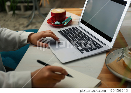Blogger working with laptop in cafe, closeup 90456943