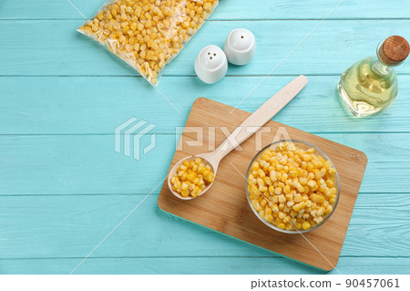 Flat lay composition with frozen sweet corn on light blue wooden table. Vegetable preservation 90457061