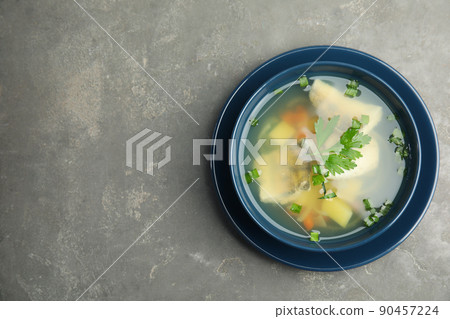Delicious fish soup in bowl on grey table, top view. Space for text Delicious fish soup in bowl on grey table, top view. Space for text 90457224