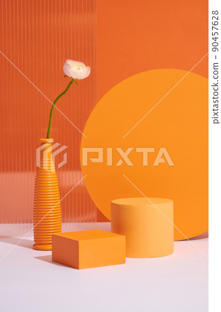 Front view of orange circle , square flower vase , pink tulips in orange background and with blank space for advertising  90457628