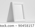 Rectangular photo frame on floor leaning at wall diagonal view 90458157