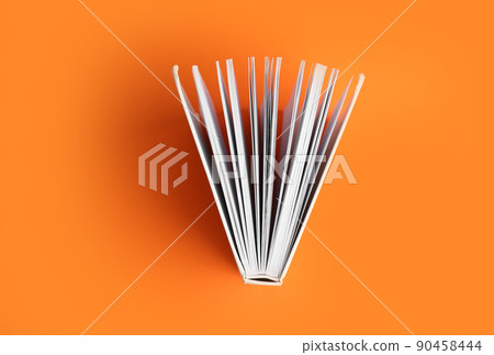 Hardcover book on orange background, top view Hardcover book on orange background, top view 90458444