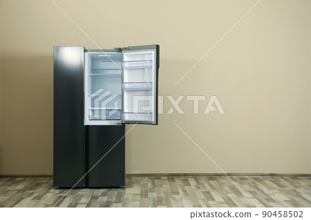 Modern refrigerator near beige wall, space for text Modern refrigerator near beige wall, space for text 90458502