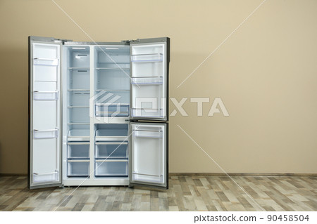 Modern refrigerator near beige wall, space for text Modern refrigerator near beige wall, space for text 90458504