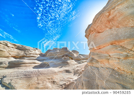 White rocks of Sarakiniko beach, Aegean sea, Milos island , Greece. No people, empty cliffs, summer sunshine, lunar landscape, deep blue sky, clouds 90459285
