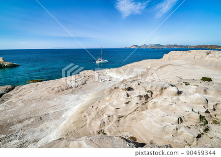 Unique white rocks of Sarakiniko beach, Aegean sea, Milos island , Greece. No people, lonely sailboat, empty cliffs, summer sunshine, clear sea waters 90459344