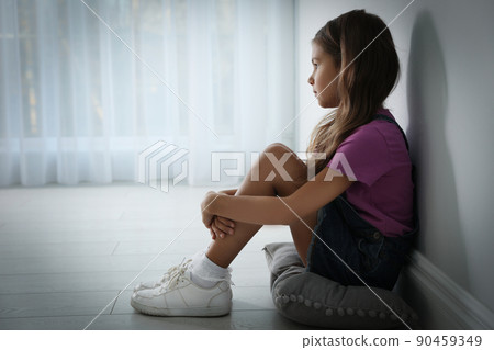 Sad little girl near white wall indoors, space for text. Domestic violence concept 90459349