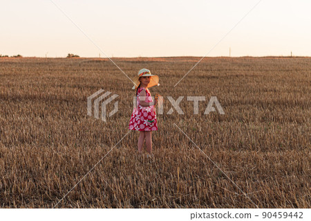 Child girl in straw hat dress in wheat field. Smiling kid in sunglasses sunset countryside. Cottagecore style aesthetic. Child girl in straw hat dress in wheat field. Smiling kid in sunglasses sunset countryside. Cottagecore style aesthetic. 90459442