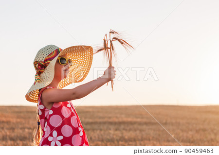 Child girl in straw hat dress in wheat field. Smiling kid in sunglasses sunset countryside. Cottagecore style aesthetic. Child girl in straw hat dress in wheat field. Smiling kid in sunglasses sunset countryside. Cottagecore style aesthetic. 90459463