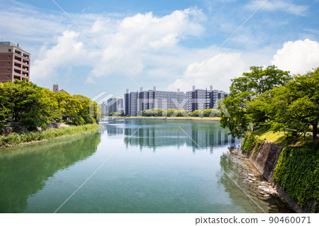 它是主要河流分支點的城市景觀。您可以在您面前看到元町的建築物。請將其用作河邊住宅的圖像。 90460071