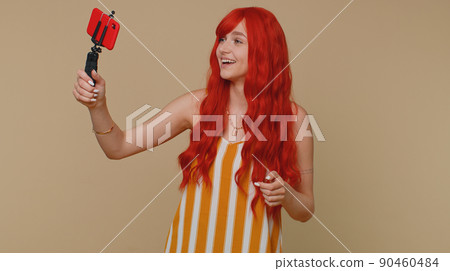 Girl blogger take selfie on mobile phone selfie stick communicate video call online with subscribers 90460484