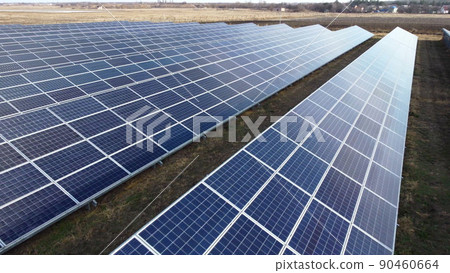 Aerial drone view flight over solar power station panels. Aerial top view of solar farm. Green energy, electrical innovation. Renewable Energy. Industrial Solar Energy Farm producing solar power. 90460664