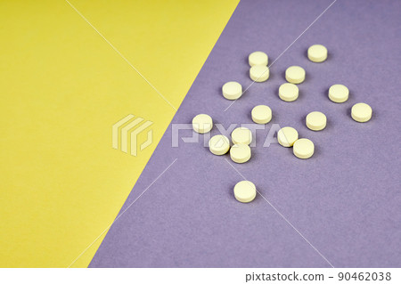 Yellow pills on colorful background 90462038