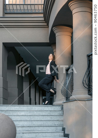 Woman in suit and heels leaned against the wall. Full-length portrait. Modern successful woman Woman in suit and heels leaned against the wall. Full-length portrait. Modern successful woman 90463750