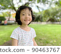 cute little girl smiles in the garden with copy space 90463767