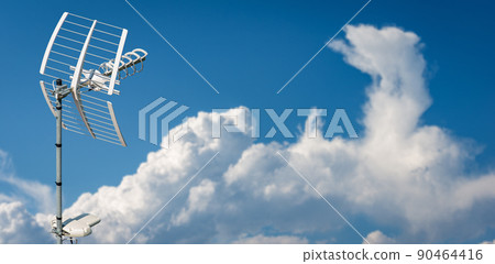 Directional Television Antenna against a Clear Blue Sky and Clouds 90464416