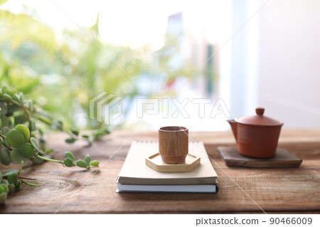 Wooden tea cup and tea pot on wooden table 90466009