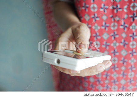 Close up of women hand holding air condition remote Close up of women hand holding air condition remote 90466547