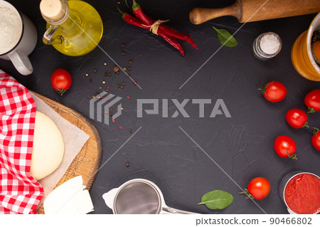Pizza and dough homemade cooking with ingredients on table. Pizza with sauce at tabletop Pizza and dough homemade cooking with ingredients on table. Pizza with sauce at tabletop 90466802