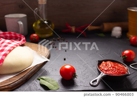 Pizza and dough homemade cooking with ingredients on table. Pizza with sauce at tabletop 90466803