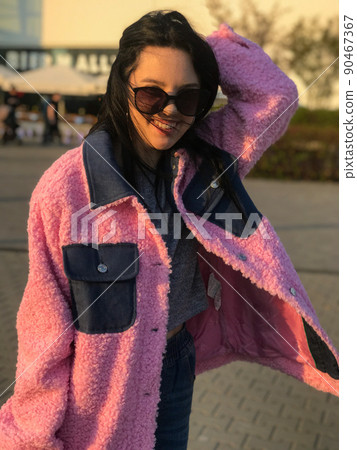 Young lady in pink jacket was shot on the street in spring on golden hour near trade center at Warsaw, Poland. Young lady in pink jacket was shot on the street in spring on golden hour near trade center at Warsaw, Poland. 90467367