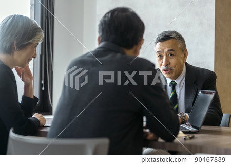 Senior business team in suits meeting in the office 90467889