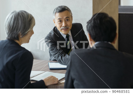 Senior business team in suits meeting in the office 90468581