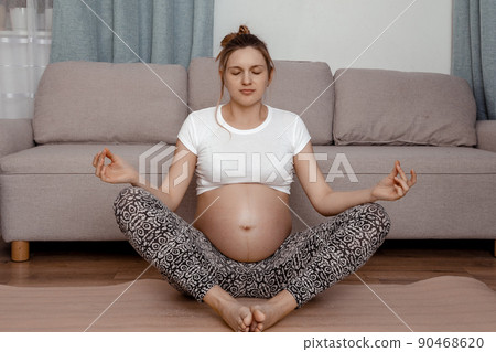 Young pregnant woman do yoga indoors. Beautiful expectant mother is doing yoga. Fitness concept. Young pregnant woman do yoga indoors. Beautiful expectant mother is doing yoga. Fitness concept. 90468620