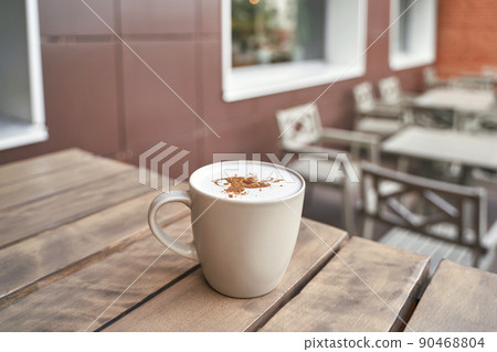 drinking coffee in outdoor cafe. Tasty latte in mug. Lunch casual atmosphere drinking coffee in outdoor cafe. Tasty latte in mug. Lunch casual atmosphere 90468804