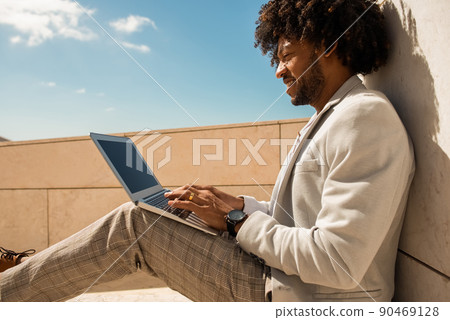 Comfortable African American man working in open air Comfortable African American man working in open air 90469128
