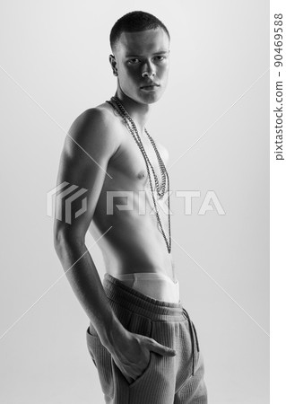Portrait of stylish, handsome young man posing shirtless, looking at camera with serious expression, Black and white photography Portrait of stylish, handsome young man posing shirtless, looking at camera with serious expression, Black and white photography 90469588