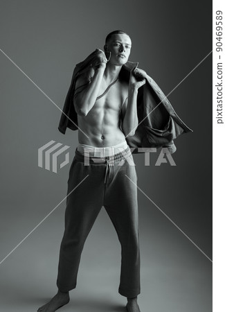 Portrait of stylish muscular young man posing, throwing shirt over shoulders. Black and white photography. Portrait of stylish muscular young man posing, throwing shirt over shoulders. Black and white photography. 90469589