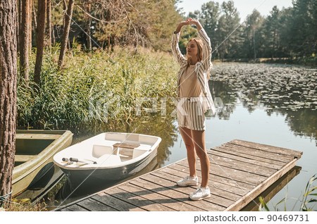 Woman practicing yoga on a landing stage Woman practicing yoga on a landing stage 90469731