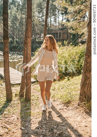 Stylish lady leaving a wooden jetty on the river Stylish lady leaving a wooden jetty on the river 90469733