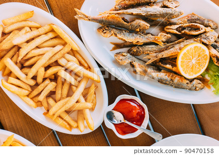 french fries and grilled fishes. fish and chips. Dish with Mullet Fish With orange. Fried fry small fishes 90470158