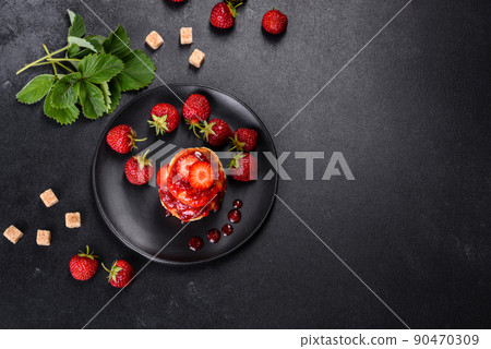 Cottage cheese pancakes with sliced strawberries and strawberry jam on a plate on a concrete background Cottage cheese pancakes with sliced strawberries and strawberry jam on a plate on a concrete background 90470309