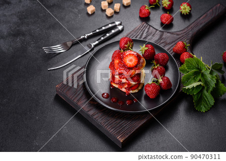 Cottage cheese pancakes with sliced strawberries and strawberry jam on a plate on a concrete background Cottage cheese pancakes with sliced strawberries and strawberry jam on a plate on a concrete background 90470311