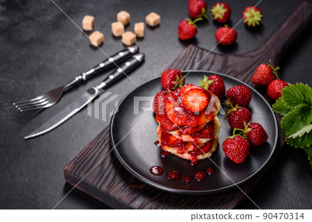 Cottage cheese pancakes with sliced strawberries and strawberry jam on a plate on a concrete background Cottage cheese pancakes with sliced strawberries and strawberry jam on a plate on a concrete background 90470314