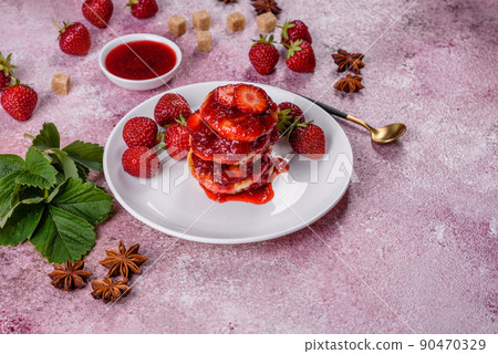 Cottage cheese pancakes with sliced strawberries and strawberry jam on a plate on a concrete background Cottage cheese pancakes with sliced strawberries and strawberry jam on a plate on a concrete background 90470329